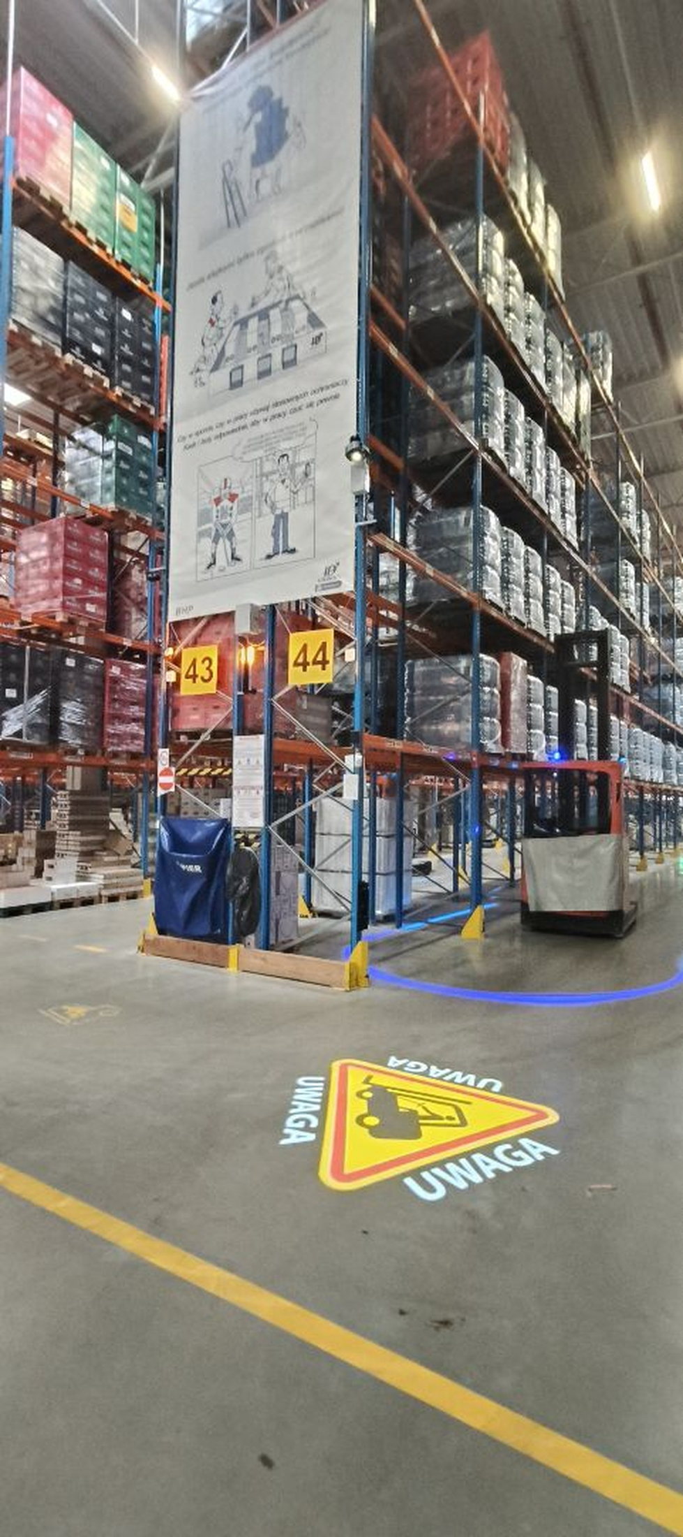 A CAUTION warning with a forklift pictogram, projected so it reads from both directions at a forklift crossing