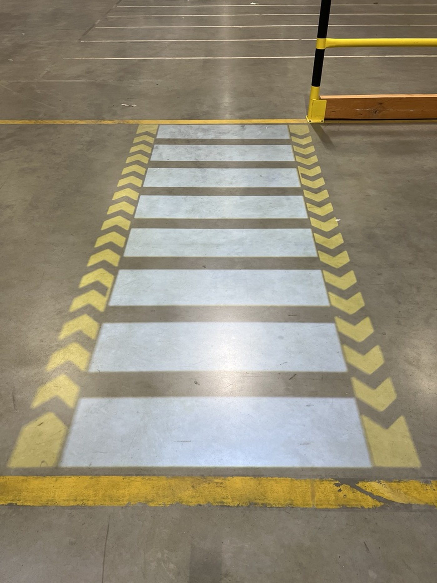 A virtual zebra crossing projected in light onto a warehouse floor