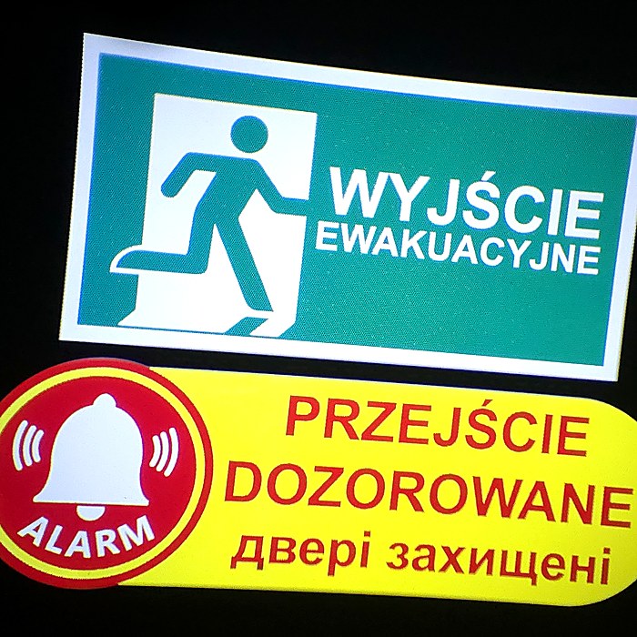 Znak wyjścia ewakuacyjnego i komunikat po ukraińsku